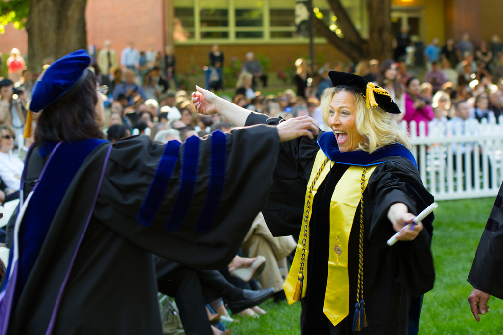 A graduate student celebrating at commencement